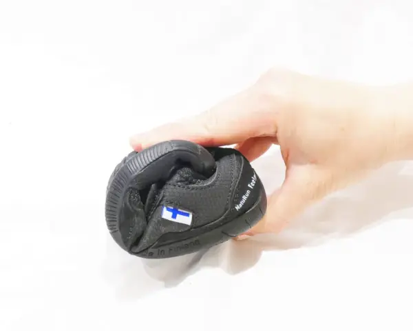 En hand håller en svart barfotasko med finska flaggan. Är barfotaskor bra eller dåligt?