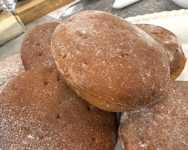 En hög med nybakade rågkakor, perfekta för ett enkelt rågkaka recept. Strödda med lite mjöl.