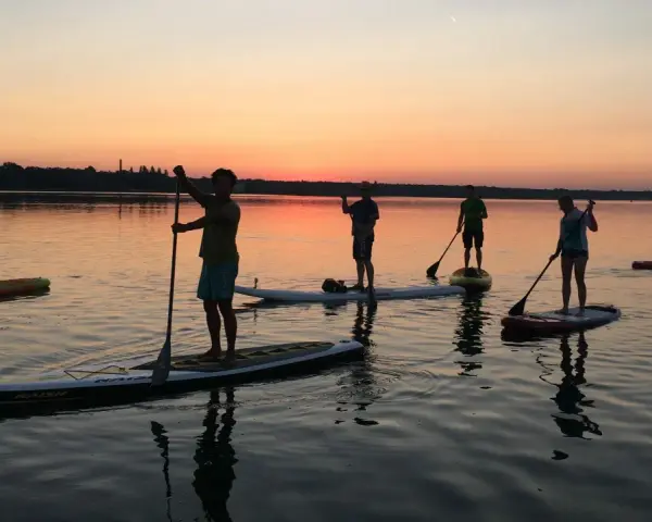 Sonnenuntergang über Berlin: Eine Gruppe genießt Wassersport auf Stand-Up-Paddle-Boards.