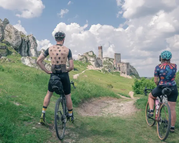 Rowerzyści podziwiają ruiny zamku na Szlaku Orlich Gniazd. Malowniczy krajobraz Jury Krakowsko-Częstochowskiej.