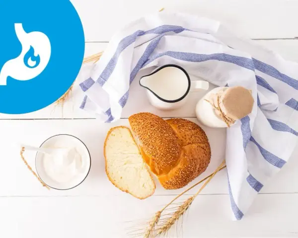 Przykładowy jadłospis przy zapaleniu żołądka: jogurt, mleko, chleb z sezamem i kłosy zbóż.