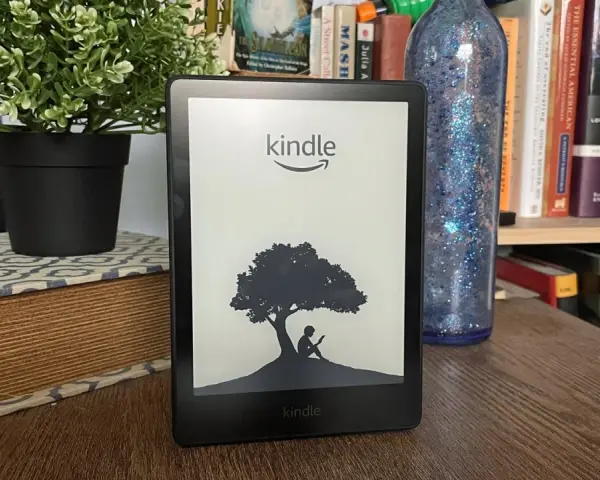 Czytnik Kindle z grafiką drzewa i siedzącą pod nim postacią. Idealny do przechowywania wielu **plików epub**.