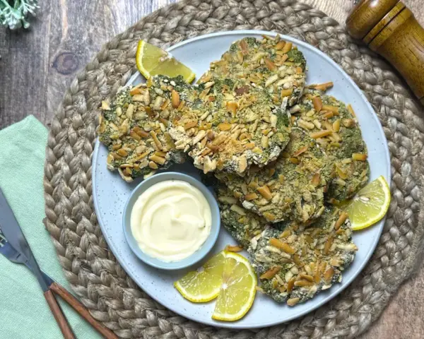 Spinacine fatte in casa croccanti, servite con maionese e spicchi di limone. Un piatto gustoso e salutare.