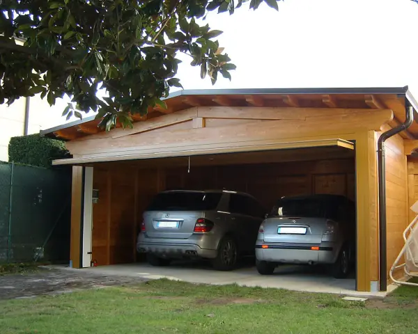 Doppio garage in legno con due auto. La struttura rispetta la normativa garage privati, offrendo un riparo sicuro e funzionale.