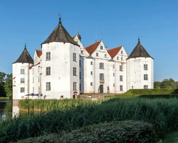 Wasserschloss in Schleswig-Holstein, ideal für die herbstferien 2025. Ein malerisches Schloss mit Türmen und Wassergraben.