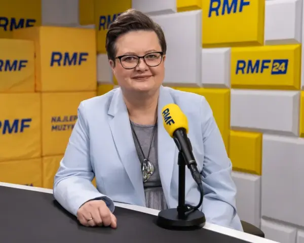 Minister edukacji w jasnej marynarce przed mikrofonem RMF FM.