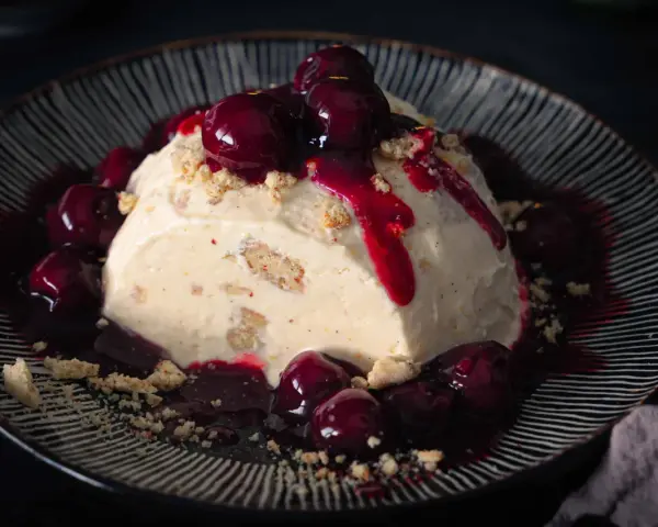 Cremiges Eisparfait mit Kirschsauce und Streuseln, ein köstliches Rezept für heiße Tage.