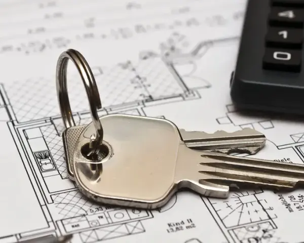 Schlüssel und Taschenrechner liegen auf Bauplänen. Ein Haus mit Garage und Zimmern ist zu sehen. Ideal für Mietrecht Oberhausen.