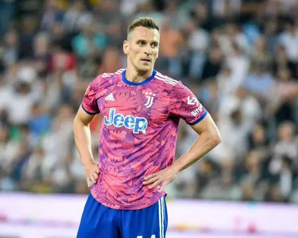 Piłkarz Arkadiusz Milik w różowej koszulce Juventusu z logo Jeep.