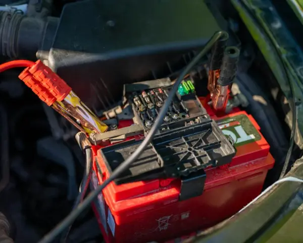 Jump starter cables connected to a car battery. This shows how a jump starter can charge a battery to get your car running again.