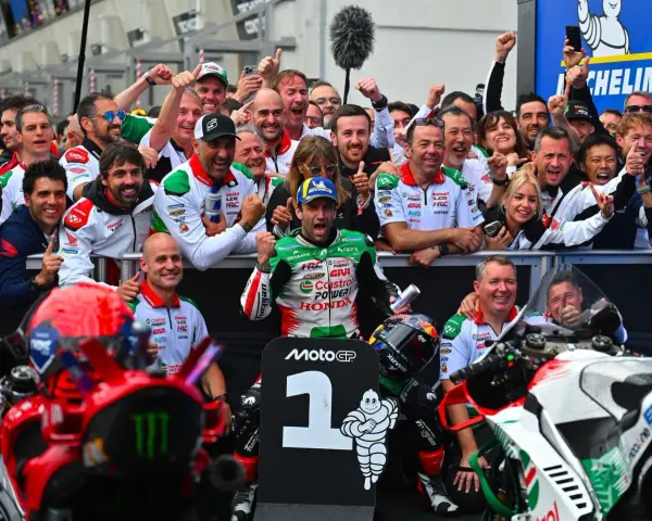 El equipo celebra un podio en el calendario MotoGP. El piloto número 1, rodeado de su equipo, muestra su alegría.