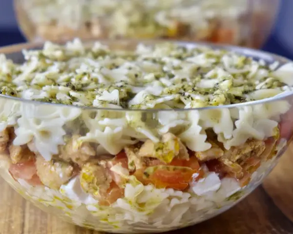 Pyszna sałatka z kurczakiem i makaronem farfalle, polana sosem pesto. Idealna na letnie dni.