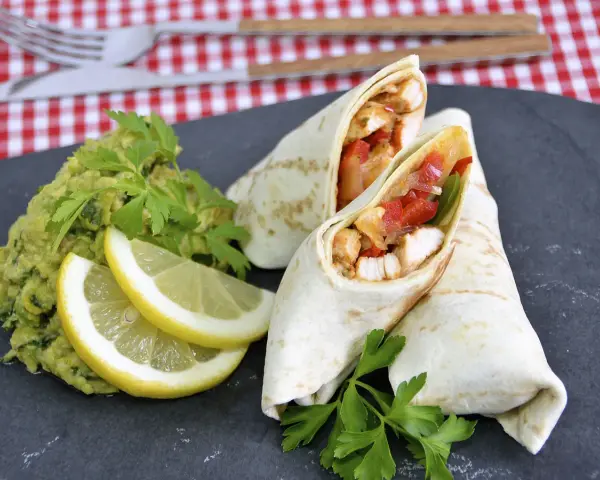 Fajitas de pollo jugosas con guacamole, limón y perejil.