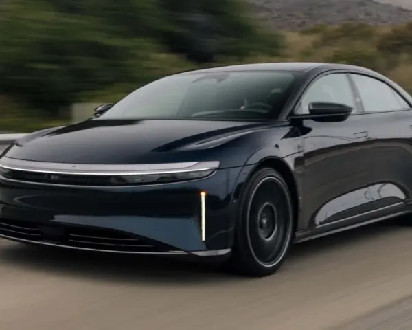 Ciemnoniebieski Lucid Air Sapphire pędzi po drodze, jego aerodynamiczna sylwetka i futurystyczne światła przyciągają wzrok.