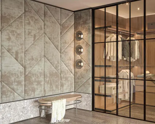 Ingresso con boiserie moderne imbottite, panchina in legno e rattan, e cabina armadio a vista con illuminazione integrata.