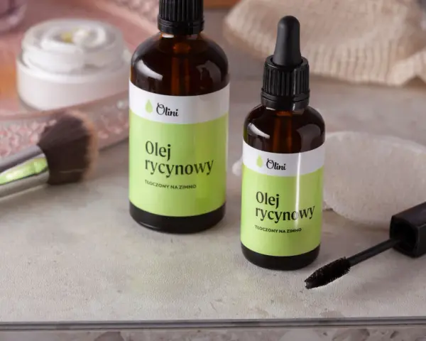 Dwie buteleczki z etykietą "Olej rycynowy" obok pędzla do makijażu i tuszu do rzęs. Idealny do pielęgnacji rzęs.