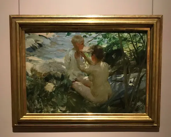 Anders Zorn fångar två barn vid en bäck. En flicka klär på en pojke i solljus.