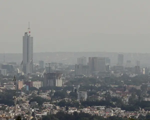 Vista panorámica de Guadalajara con edificios altos y una neblina que afecta la calidad del aire.