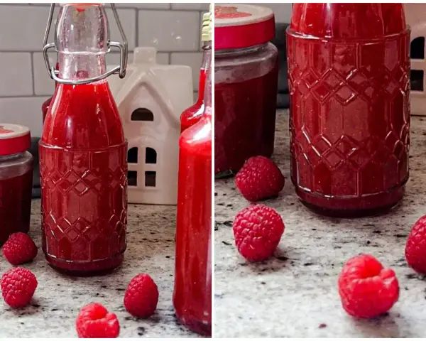 Himbeer Schnaps selber machen: Flaschen gefüllt mit rotem Likör, frische Himbeeren und ein kleines weißes Haus.