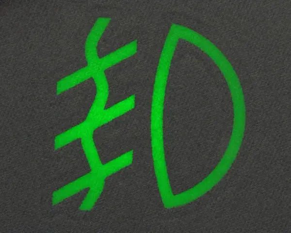 Zielony symbol przeciwmgielny na ciemnym tle.