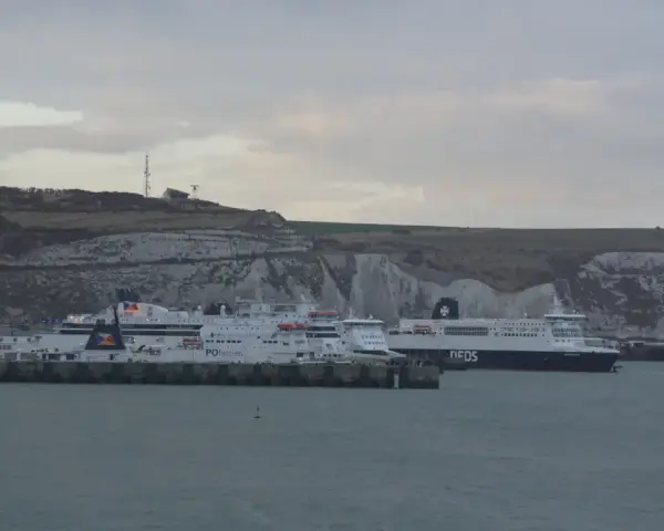 Kilka promów cumuje przy białych klifach. Jeden z nich, z napisem "DFDS", szykuje się do rejsu do Szkocji.