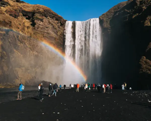 Turyści pod wodospadem Skógafoss na Islandii. Czy do Islandii trzeba mieć paszport? Tak, dla obywateli spoza strefy Schengen.