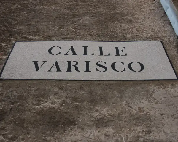 Targa in pietra con scritta "CALLE VARISCO" a Venezia, incastonata in un muro grezzo.