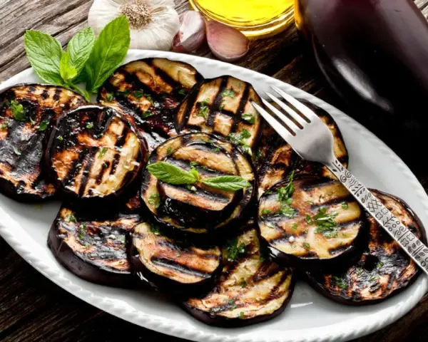 Melanzane grigliate condite con erbe fresche e olio d'oliva. Un contorno saporito e facile da preparare.