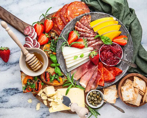 En härlig charkbricka med salami, prosciutto, ost, jordgubbar, marmelad och kex. Perfekt för mingel!