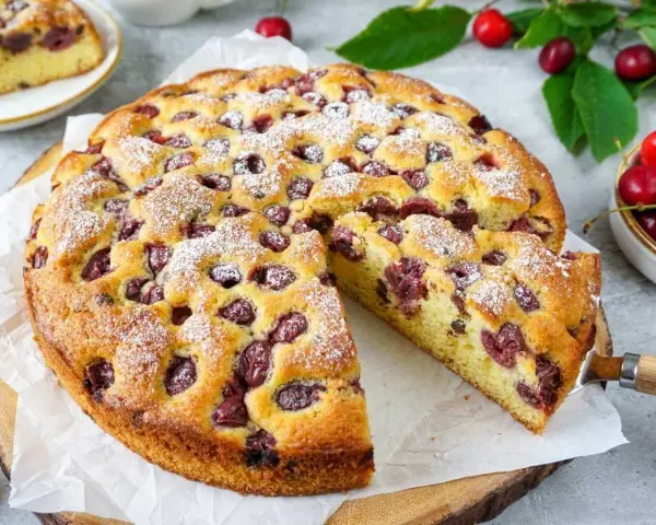 Saftiger Kirschkuchen, perfekt für das Kirschkuchen Rezept. Mit Puderzucker bestäubt und voller Kirschen.