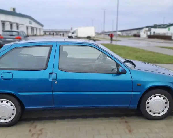 Błękitny Citroen ZX stoi na parkingu.