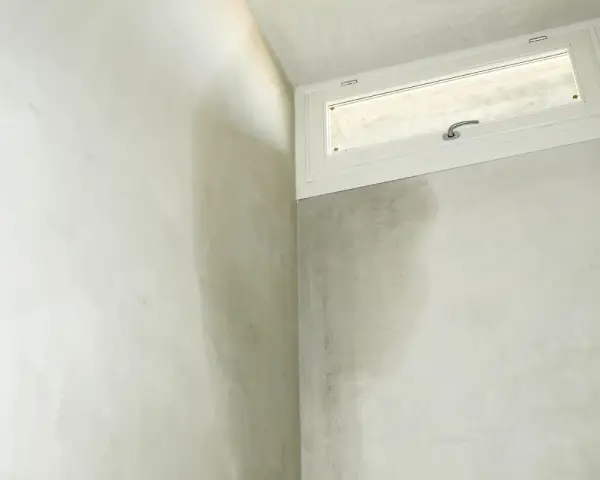 Angoli di un muro perimetrale con evidenti macchie scure dovute a infiltrazioni acqua piovana.