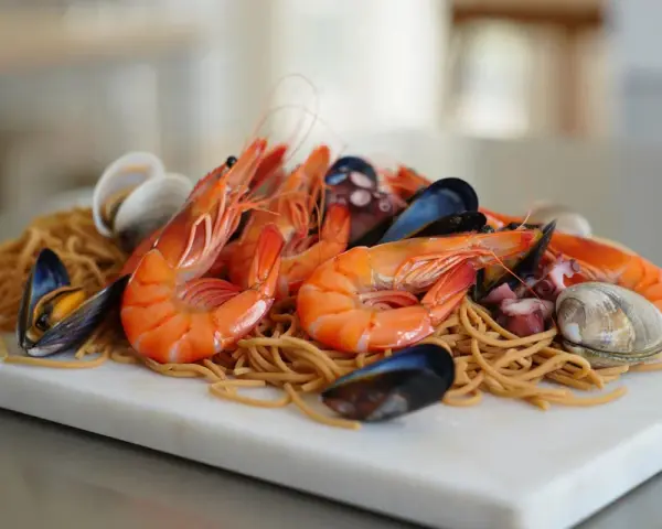 Fideuá de marisco con gambas, mejillones, almejas y pulpo sobre fideos finos.