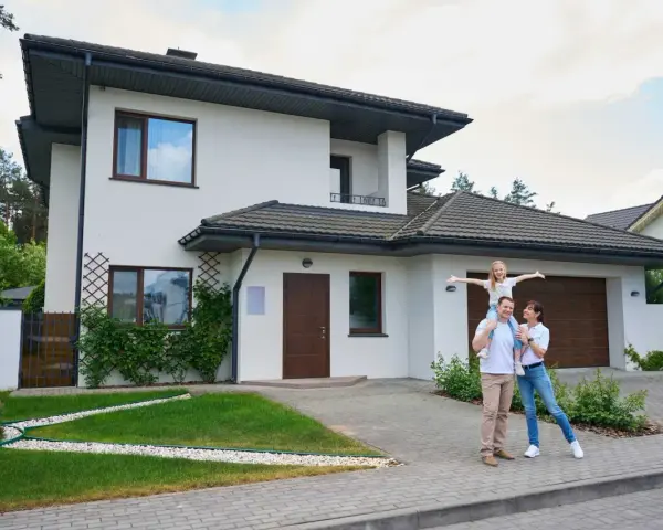 Szczęśliwa rodzina przed nowoczesnym domem. Realizacja marzeń o własnym M, gdzie koszt budowy domu 100m2 jest w zasięgu ręki.
