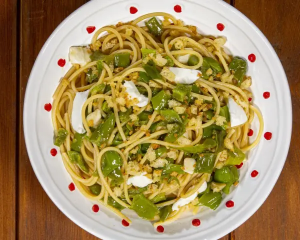 Spaghetti con friggitelli, mozzarella e pangrattato croccante. Un piatto semplice e gustoso, perfetto per un pranzo veloce.