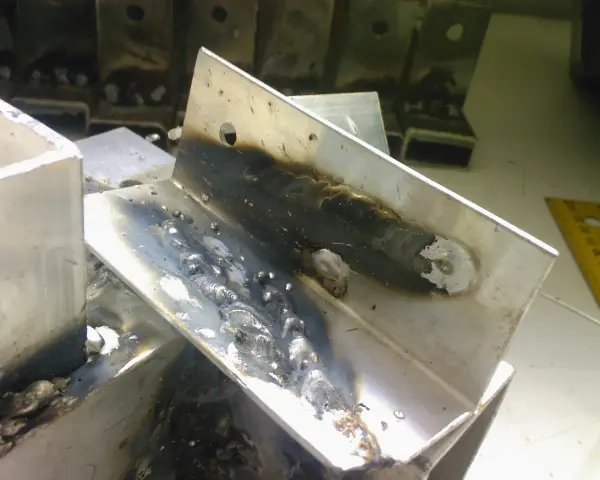Fragmenty aluminium po spawaniu migomatem. Widoczne ślady spoin i nalot.