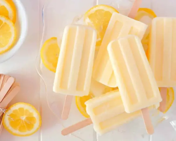 Erfrischendes Zitronen Wassereis selber machen ist einfach! Hier sind cremige Eis am Stiel mit frischen Zitronenscheiben.