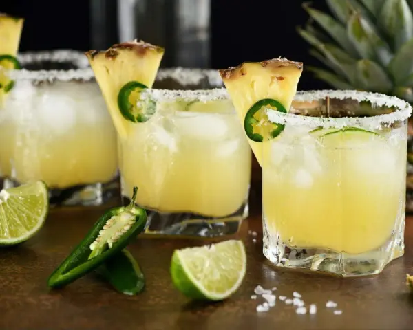 Orzeźwiający drink z coroną, ananasem i jalapeño, z solą na brzegu szklanki. Idealny na upalne dni.