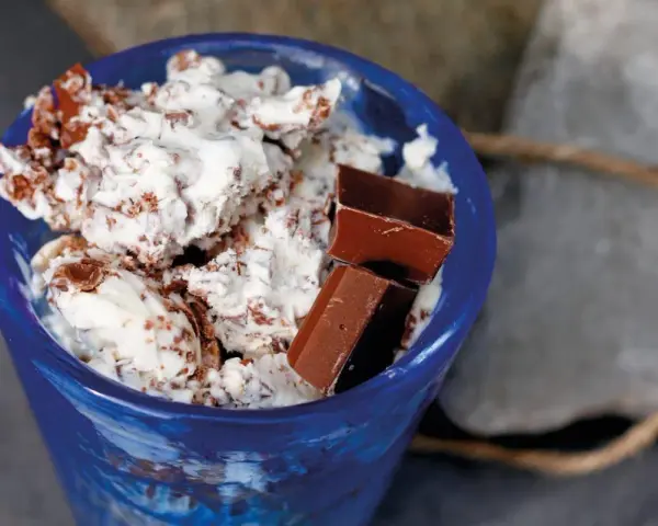 Blå skål med krämig glass, chokladbitar och strössel. Ett enkelt glass recept för en varm sommardag.