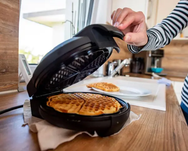 Nach dem Genuss von Waffeln wird das Waffeleisen gereinigt.