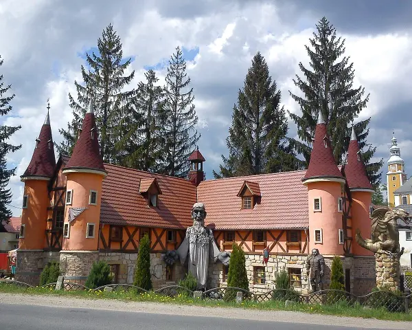 Zamek śląskich legend z wieżyczkami i kamiennymi rzeźbami.
