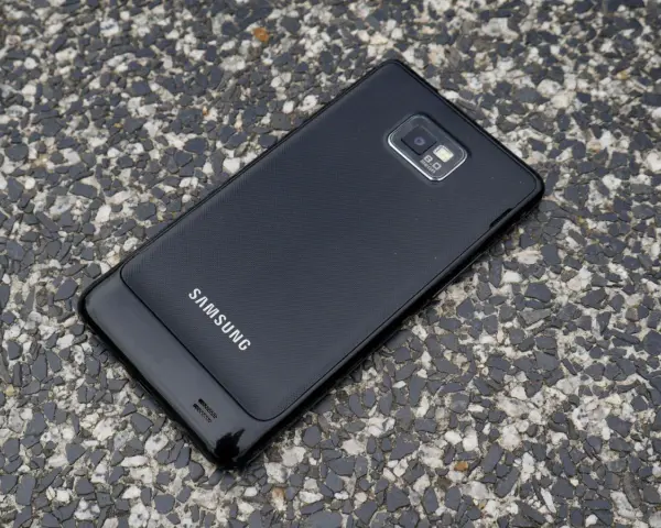 Czarny Samsung Galaxy S2 leży na kamienistej nawierzchni.