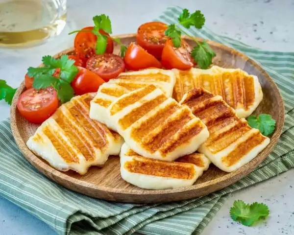 Grillowany ser halloumi z pomidorkami koktajlowymi i kolendrą. Idealny pomysł, co zrobić z sera halloumi na lekki posiłek.
