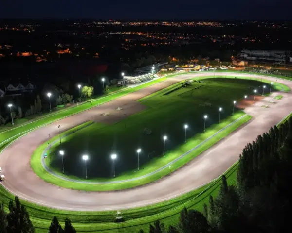 Vue aérienne d'un hippodrome illuminé la nuit, rappelant le nombre d'hippodrome en France.