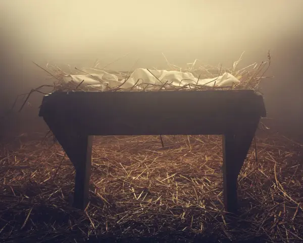 Pusta żłób, symbol początku, gdzie na początku było słowo. Siano i białe płótno w mglistym świetle.