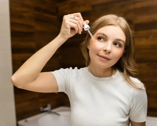 Donna applica siero viso con contagocce, concentrandosi sul giusto retinolo percentuale per la sua pelle.