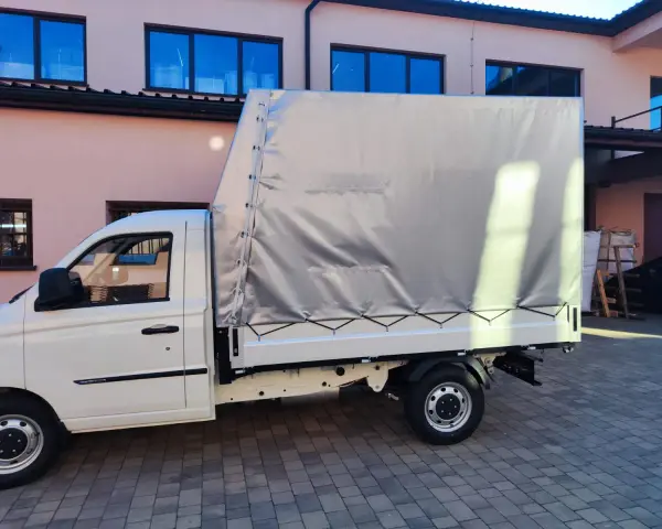 Biały samochód ciężarowy do 2,5 tony z plandeką gotowy do transportu towarów.