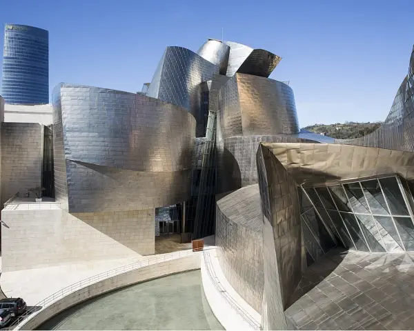Spektakularny efekt Bilbao: falujące, metaliczne formy Muzeum Guggenheima w Bilbao, odbijające niebo i otoczenie.