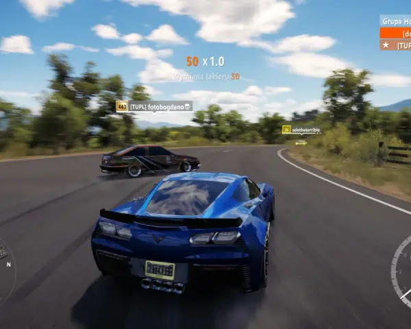 Wyścig w Horizon 3: niebieski Chevrolet Corvette ściga się z innymi autami na krętej drodze.