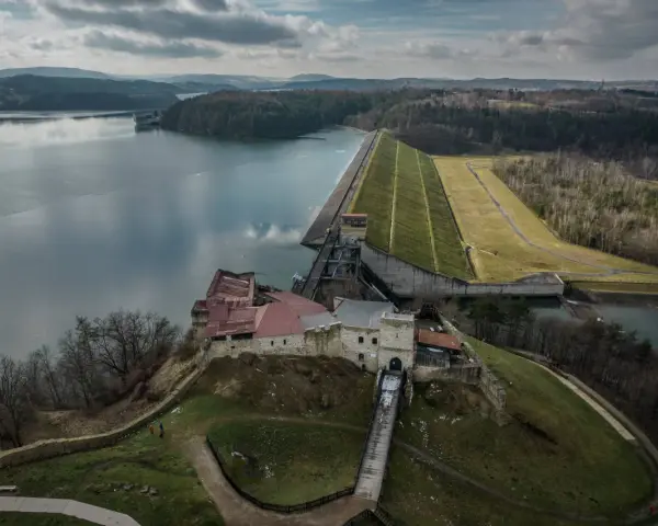 Zamek w Dobczycach i potężna zapora wodna – to główne dobczyce atrakcje. Widok z lotu ptaka na jezioro i okoliczne wzgórza.